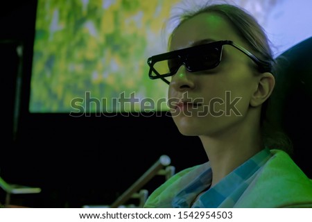 Portrait of woman face with 3d glasses looking around in movie theater with shaking seat, panoramic screen and low light illumination. Technology, 3d movie, entertainment, leisure time, cinema concept Royalty-Free Stock Photo #1542954503