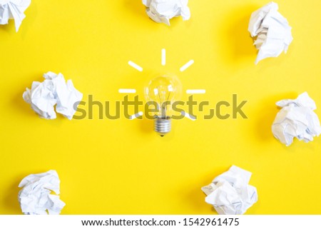 
light bulb of ideas on a yellow background with papers. mental work