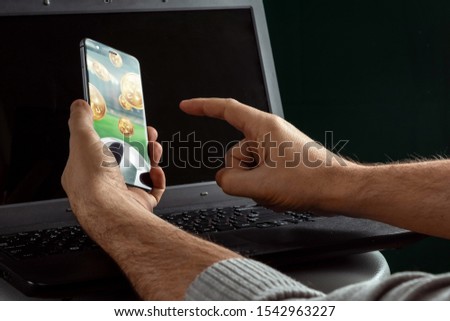 Smartphone in hand Sports Betting on laptop background. Bets, sports betting, bookmaker. Mixed media.