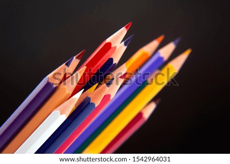 Colored pencils for drawing on a dark background. Education and creativity. Leisure and art
