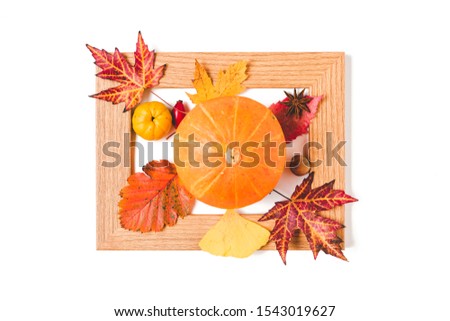 Picture frame with autumn leaves, quince and orange pumpkin. Creative thanksgiving day or halloween concept. flat lay