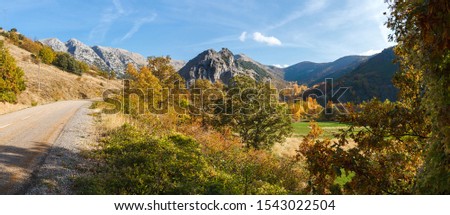 Panoramic view of secondary road in beautiful autumn landscape with valley and mountains in the background  
