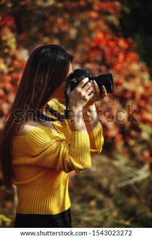 woman photographer takes pictures in nature, the photographer in action