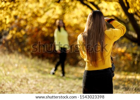 young woman photographer takes pictures of model in nature, the photographer in action
