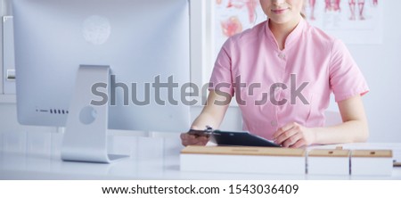 Woman doctor sitting with folder at hospital