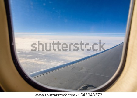 View on white clouds and wing from airplane window