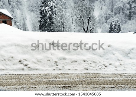Tire tracks on the snowy ground under blizzard.