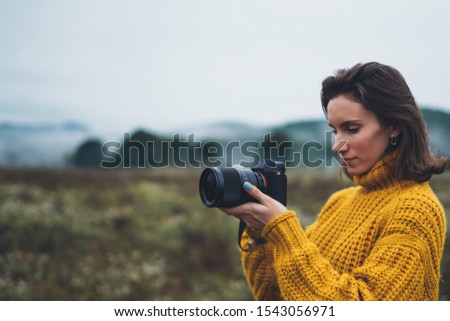 photographer traveler take photo on video camera closeup on background autumn foggy mountain, tourist shooting nature mist landscape outdoor, hobby adventure concept, copy space mockup
