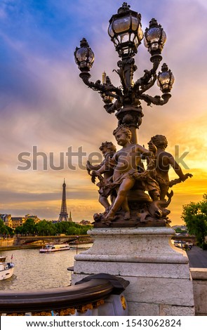 Street lantern on the Alexandre III Bridge with the Eiffel Tower in the background in Paris, France. Architecture and landmarks of Paris. Sunset cityscape of Paris