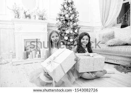 Small cute girls received holiday gifts. Best toys and christmas gifts. Kids little sisters hold gifts boxes interior background. Children friends excited unpacking their gifts. What a great surprise.