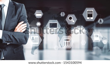 Businessman with digital business interface standing in blurry office interior. Technology and innovation concept. Multiexposure 