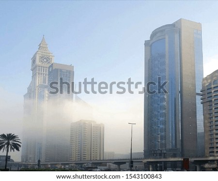A picture of the clouds rushing through buildings in Dubai 