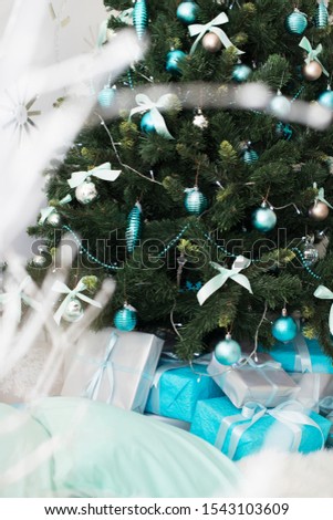 Christmas tree with lights garlands blue and silver  balls, toys, gifts decor of the house new year. Tiffany blue 
sleds and skates on a 
 white fluffy background. New Year card concept