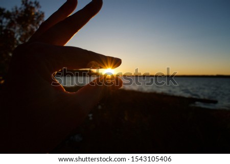Setting Sun pinched between finger and thumb. 