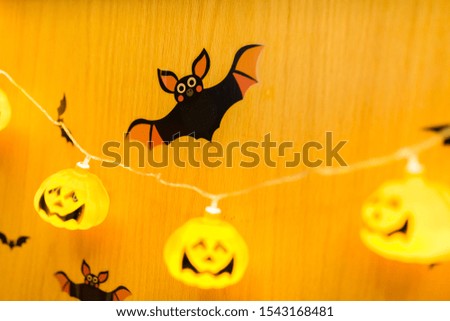 Scary Halloween decoration on wooden wall. Halloween card concept. Spooky glowing faces with candlelight.