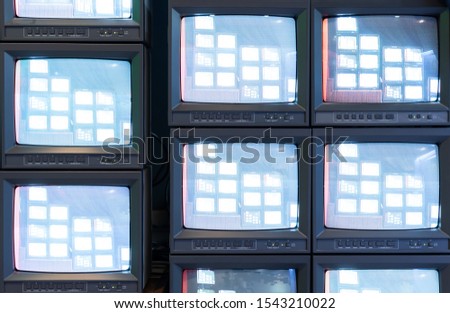 Stack of old analog television monitor with live signal program in broadcasting studio, retro TV tube screen display