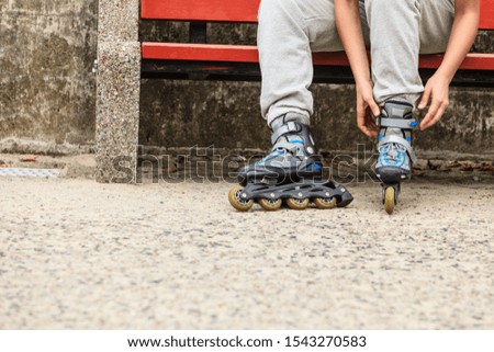 Closeup of woman girl putting on roller skates outdoor.