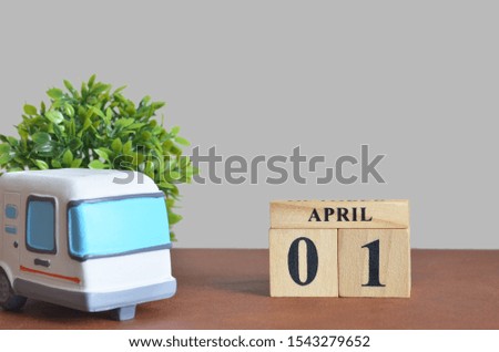 April cover design with number cube and car, Date 1.