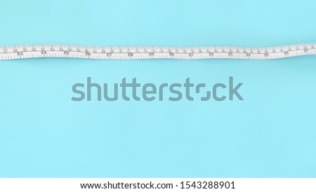 close up of measure tape on blue background