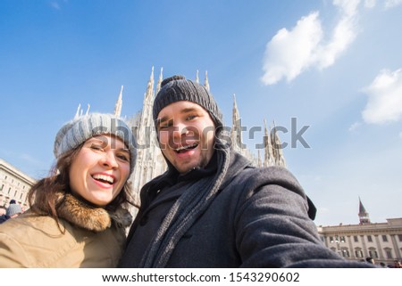 Couple taking self portrait in Duomo square in Milan. Traveling and relationship concept