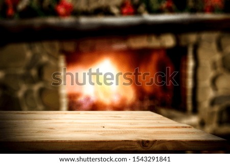 Table background of free space and winter background of fireplace in home interior. 