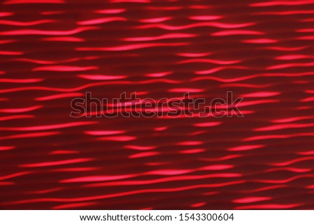 light patterns on a red wall different shades