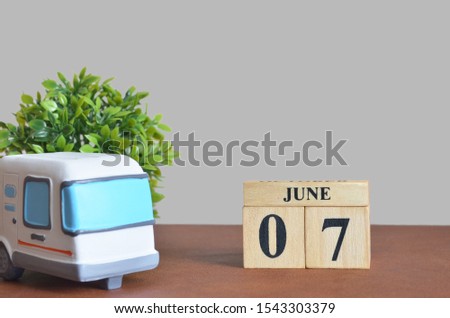 June cover design with number cube and car, Date 7.