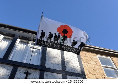 A war memorial flag flying to mark remembrance with the words lest we forget