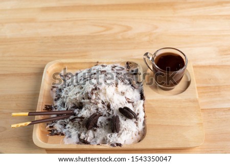 Bingsu or chocolate clear ice in a wooden cup with chocolate sauce