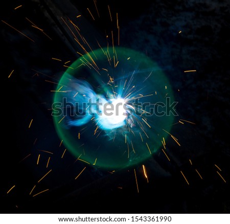 Sparks from welding at a construction site as a background.