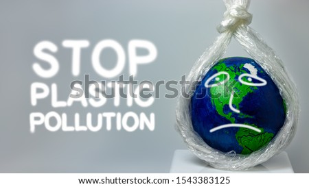 Stop plastic pollution. A plastic stretch film kills the planet earth. World environment day. Pollution problem concept. Planet earth is sad. The world is dying of garbage.