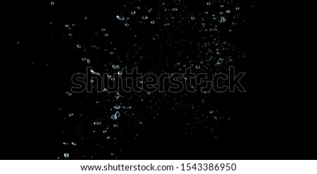 Blurry images of soda water bubbles splashing and floating up to top of water surface which little and big circle texture shaped up by gas power in carbonate drink make refreshing on black background Royalty-Free Stock Photo #1543386950