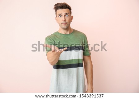 Irritated young man on color background