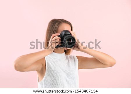 Female photographer on color background