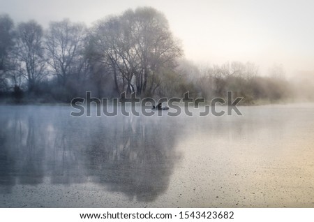 Fishing on the river in the morning. Foggy morning man on a boat fishing. In autumn