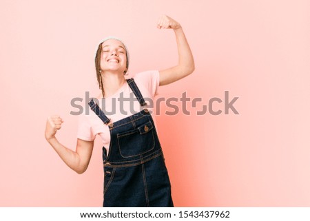 Hispter teenager woman raising fist after a victory, winner concept.