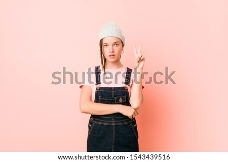 Hispter teenager woman showing number two with fingers.