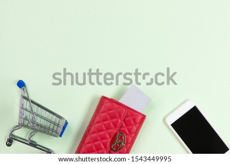 Wallet with credit card, on table with cup of tea and dessert. Top view with copy space