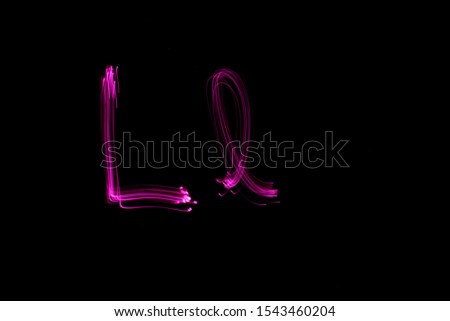 Long exposure photograph of the letter L in upper and lower case in pink neon colour in an abstract swirl, parallel lines pattern against a black background. Light painting photography.