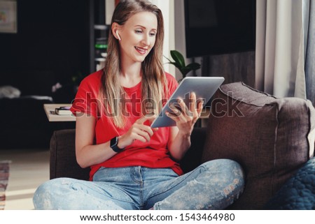 Female freelance worker doing projects on mobile connected gadgets. Girl typing on tablet and surfing internet. Useful apps for work and education, creative features, editing, taking pictures, videos.