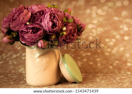 Pink peonies in vase on bokeh background - retro styled photo. soft focus.