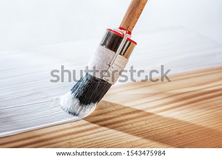 Applying white primer paint on wood Royalty-Free Stock Photo #1543475984