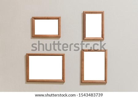 Several a lot of small empty picture frames on a light wall. four frames on the wall copy space isolated