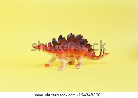 dinosaur toy isolated on yellow background with copy space 