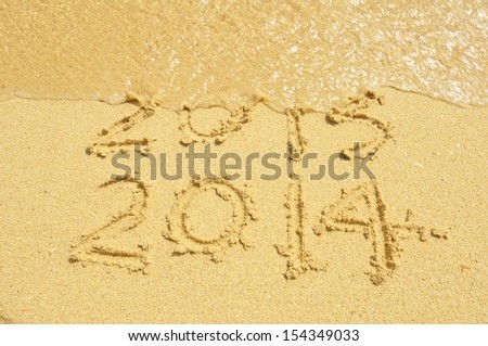 Happy New Year 2014 replace 2013 concept on the sea beach