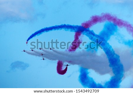 The Red Arrows Fly in tight formation during a flying display on Armed Forces Day. Their skill and precision is obtained through incessant drill and practice and makes them the world's best Royalty-Free Stock Photo #1543492709