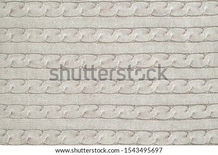 The tail is made of beige knitted fabric texture. Machine knitting texture close up Photo. Beige grey knitted background. the texture of the warm fabric