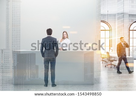 Business people standing near reception desk in modern office with white walls, arched windows and open space area in background. Toned image double exposure