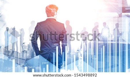 Rear view of business leader and silhouettes of his colleagues in modern city with double exposure of HUD interface and graphs. Concept of leadership. Toned image