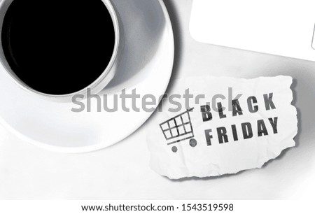 A cup of coffee and ripped paper with Black Friday text on the desk. Black Friday concept